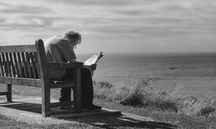 Foto de Craig Dennis: https://www.pexels.com/es-es/foto/foto-en-escala-de-grises-del-hombre-sentado-en-un-banco-de-madera-marron-leyendo-el-periodico-durante-el-dia-128428/